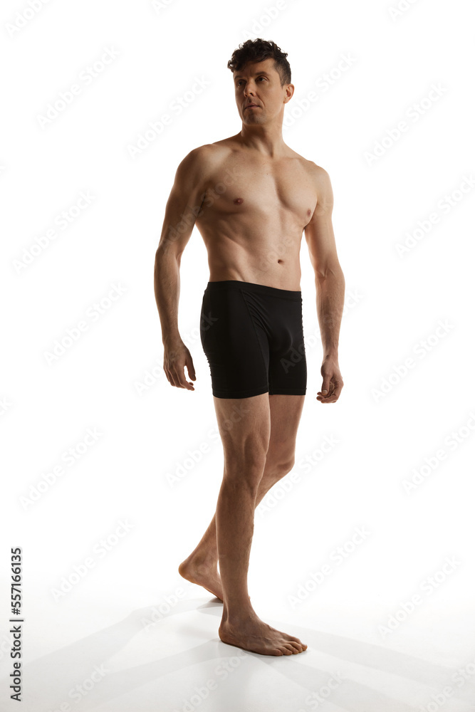 Portrait of mature handsome man posing shirtless in black boxers over white studio background. Muscular body shape. Men's health and beauty Portrait of mature handsome man posing shirtless in black boxers over white studio background. Muscular body shape. Men's health and beauty