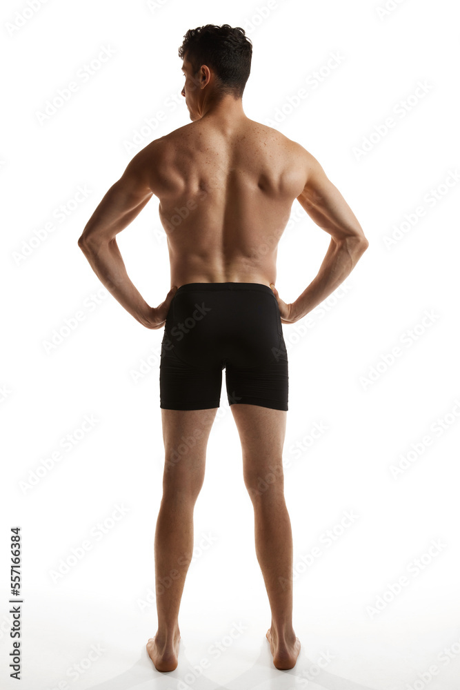 Rear view photo of mature handsome man posing shirtless in black boxers over white studio background. Strong back. Men's health and beauty Rear view photo of mature handsome man posing shirtless in black boxers over white studio background. Strong back. Men's health and beauty