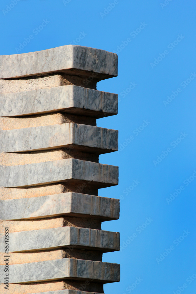 Column or stack of stone blocks against blue sky