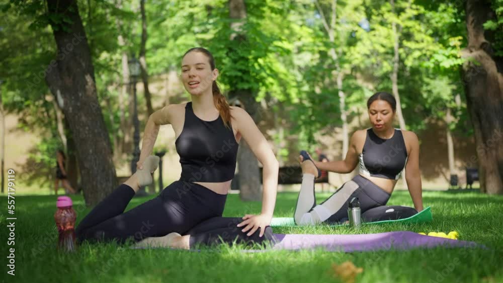 Women doing stretching exercises for flexibility in park, training partners Women doing stretching exercises for flexibility in park, training partners