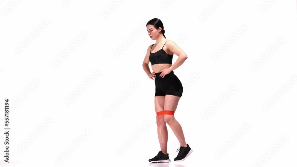 Young sportive girl training with fitness elastic bands over white studio background. Doing lunges. Legs and buttocks exercises. Concept of sport, health, fitness, body care Young sportive girl training with fitness elastic bands over white studio background. Doing lunges. Legs and buttocks exercises. Concept of sport, health, fitness, body care