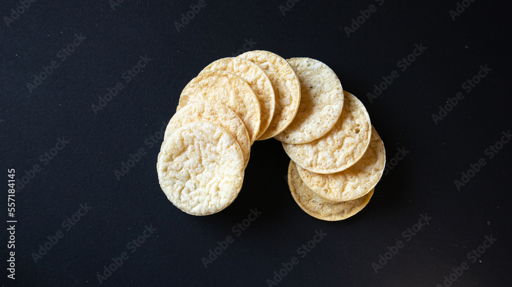 Puffed chips placed in semi circle on black background, Healthy Potato