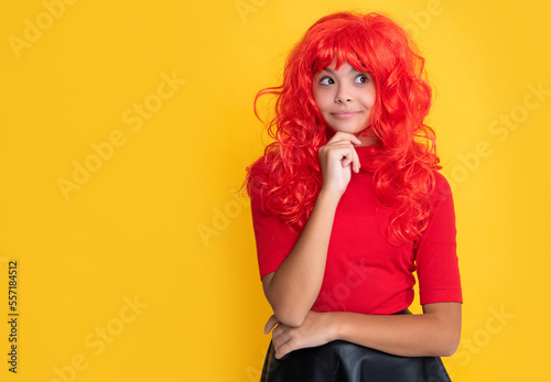 dreamy teen child with red long hair on yellow background