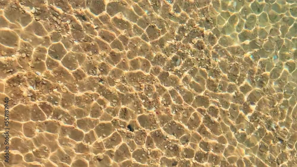 Background of crystal clear water. Close-up of sea water with light reflections. Natural texture top view. Bright sun glare on the surface of the water. Red sea with ripples on a sunny day. Egypt Background of crystal clear water. Close-up of sea water with light reflections. Natural texture top view. Bright sun glare on the surface of the water. Red sea with ripples on a sunny day. Egypt