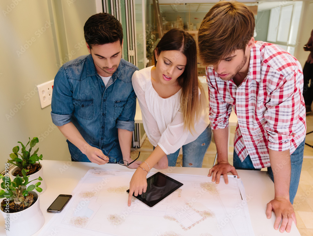 Three Architects and engineers working at the Office Checking Blueprints Three Architects and engineers working at the Office Checking Blueprints