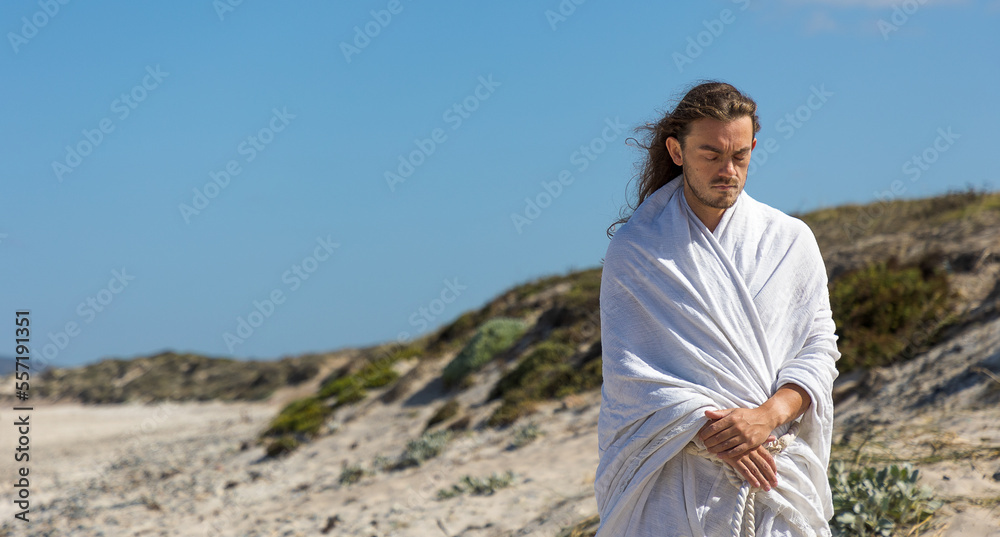 holy man looks down- white robe, beard and long hair like Jesus