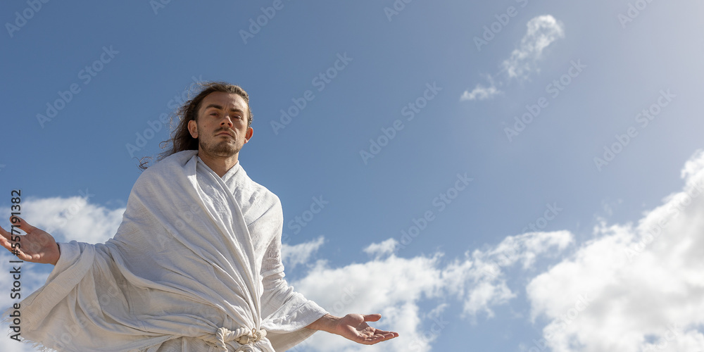 holy man (like Jesus) looks into camera with arms open and welcoming