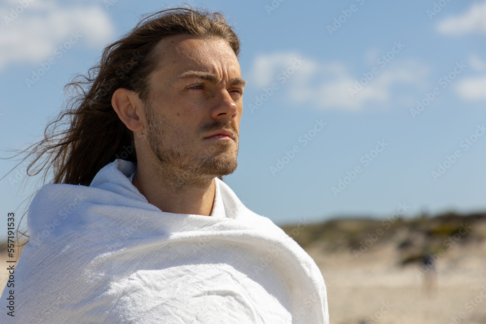 Portrait of serious bearded man in white robe looking to future