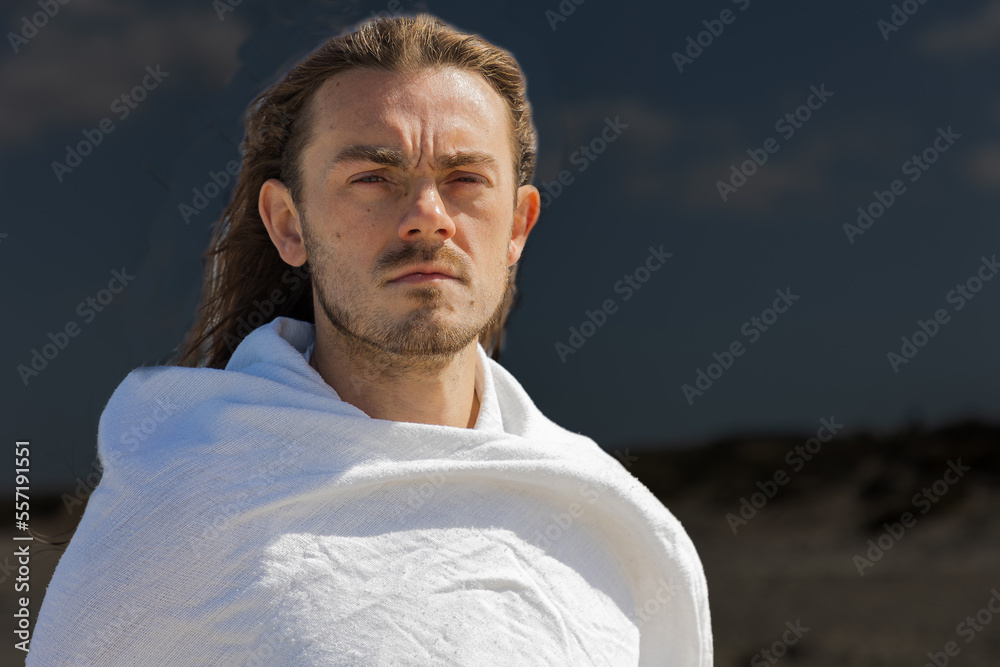 Portrait of a man who looks like Jesus against a dark sky