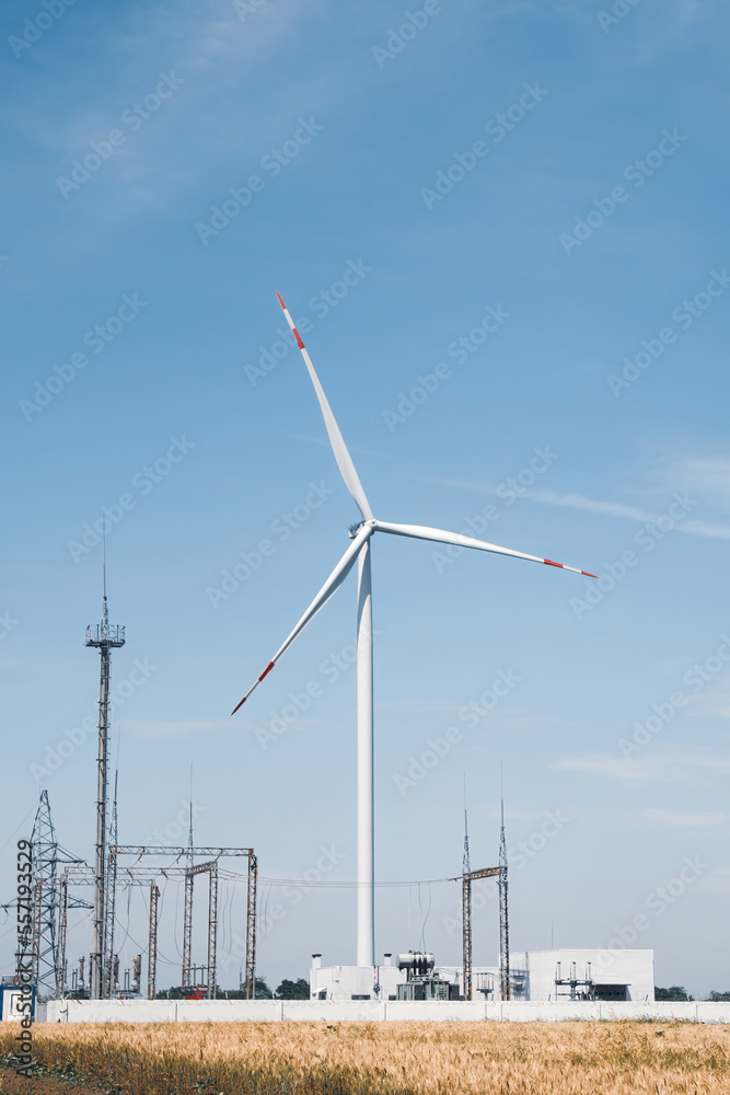 Wind turbine helps power substation use renewable energy. Wind mill produces clean and ecofriendly power for electricity distribution substation