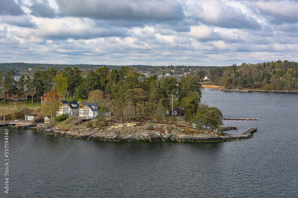 Landscape with Scandinavian skerries in the Gulf of Bothnia of the Baltic Sea. A unique natural landscape with rocky islets, overgrown with forest, with neat houses and piers