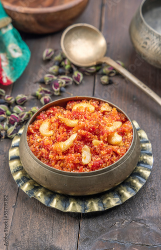 Gajar ka halwa is, Popular Indian dessert pudding made with grated carrots, milk, sugar and nuts served hot with a garnish of almonds, cashew nuts and pistachios.
