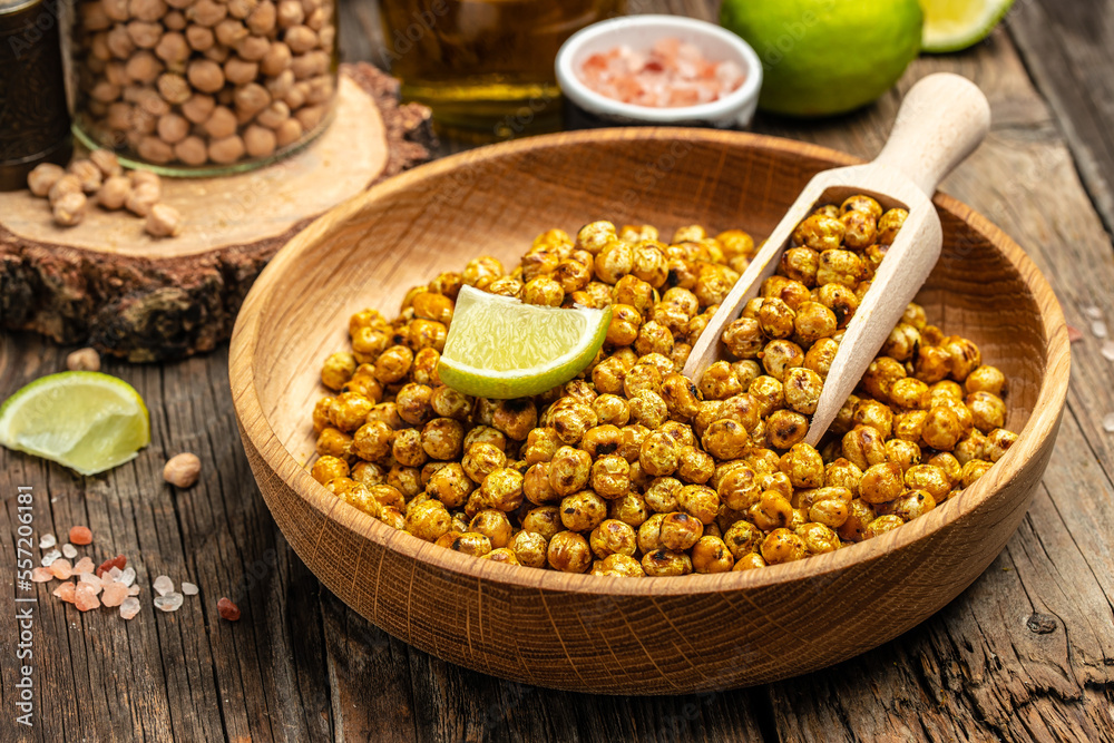 fried spicy chickpeas with lime on wooden table background. Food recipe background. Close up fried spicy chickpeas with lime on wooden table background. Food recipe background. Close up