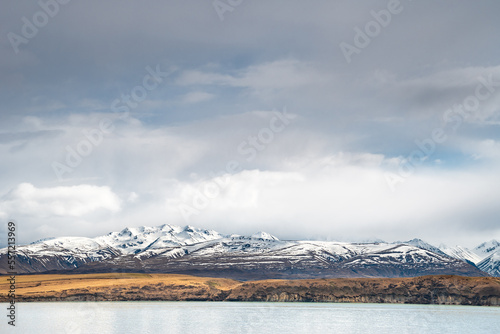 Scenic view of Lake Tekapo east bank. Beautiful view driving along the Lilybank Road from Lake Tekapo Park towards Motuariki View Point. Stunning southern alps view along the journey.  photo