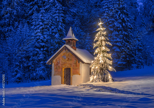 Beleuchteter Weihnachtsbaum mit Kapelle bei Nacht, Winterlandschaft, Bayern, Deutschland photo