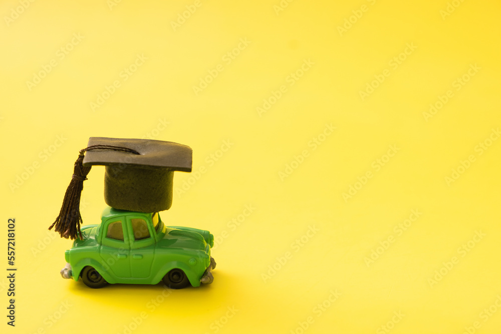 Fototapeta premium Toy mini car with a graduated cap. Driving leaning concept