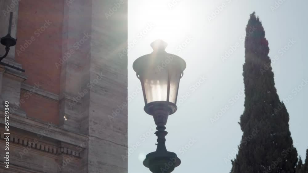 Street lamp in sunlight, retro street lantern against ancient building architecture background, isolated street lamp outdoor in sun flares Street lamp in sunlight, retro street lantern against ancient building architecture background, isolated street lamp outdoor in sun flares