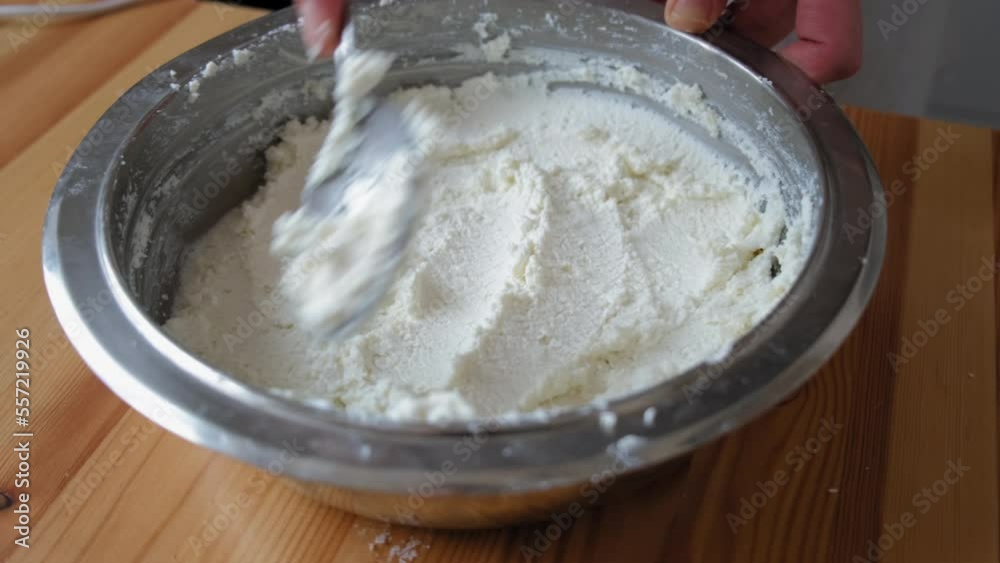 the process of cooking tiramisu. a spoon levels the crushed cottage cheese. crushed cottage cheese. cottage cheese in a plate the process of cooking tiramisu. a spoon levels the crushed cottage cheese. crushed cottage cheese. cottage cheese in a plate