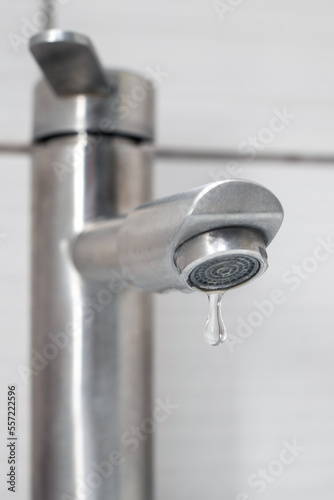 Water dripping from the faucet in the bathroom. Water faucet close-up. Saving water