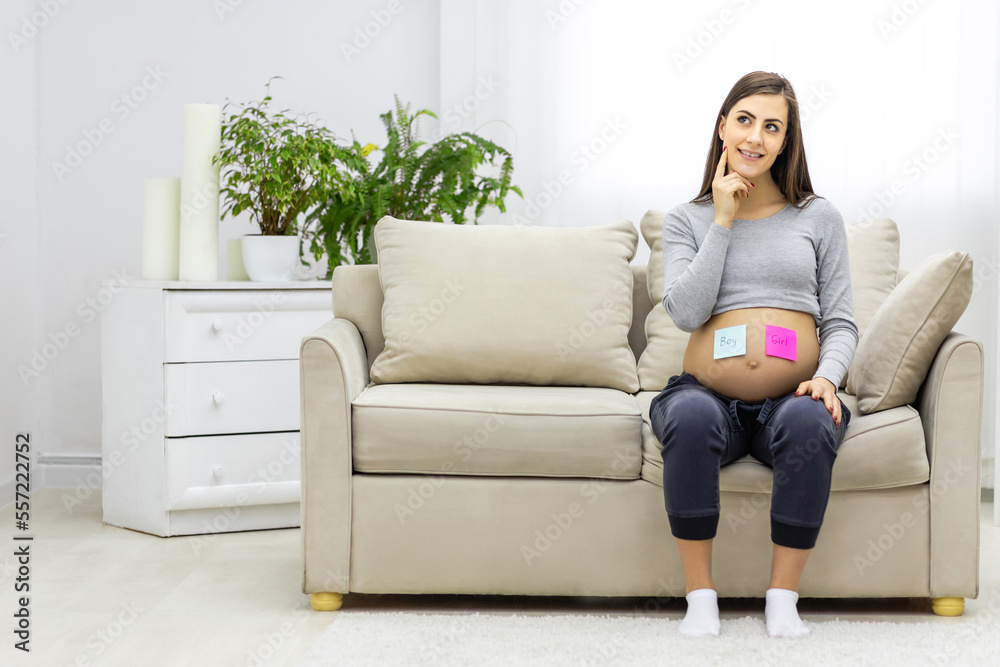 Photo of positive pregnant woman with pink and blue papers on the stomach which mean gender of future baby. Photo of positive pregnant woman with pink and blue papers on the stomach which mean gender of future baby.
