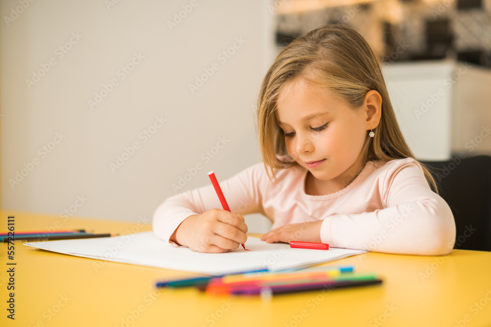Beautiful little girl enjoys drawing at her home. Beautiful little girl enjoys drawing at her home.