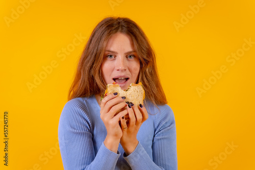 Vegetarian woman biting a sandwich on a yellow background  healthy vegetarian food