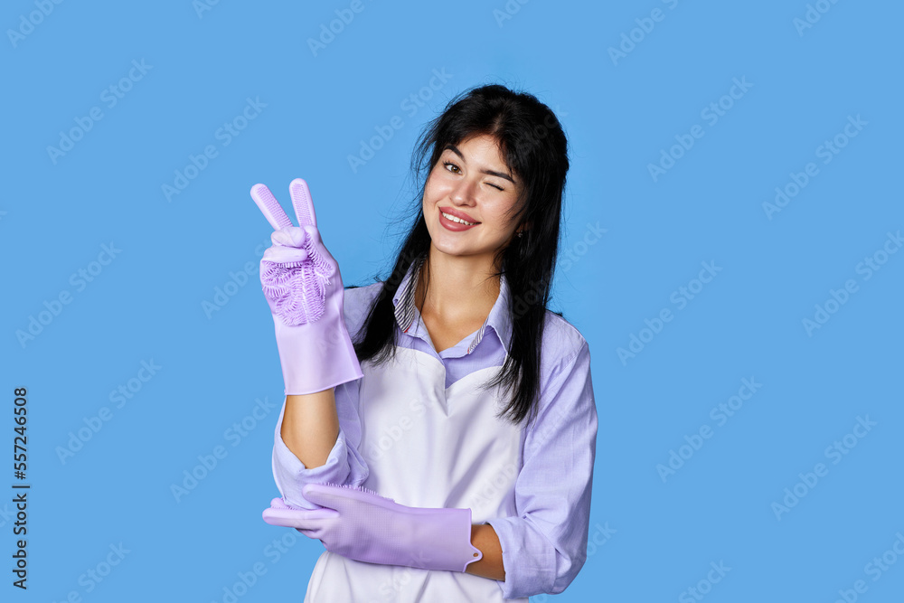 caucasian woman in rubber gloves isolated on blue background. caucasian woman in rubber gloves isolated on blue background.