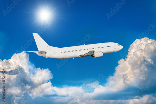 White passenger jet plane fly in the air above picturesque clouds