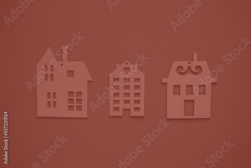 Real estate agency. Flat wooden houses on red background view from above. Concept of a creative real estate agency, individual selection of housing