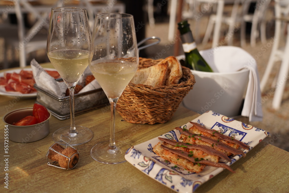 Mediterranean lunch or dinner - cava sparkling wine and traditional spanish snacks - hamon, anchovies, pan con tomate.