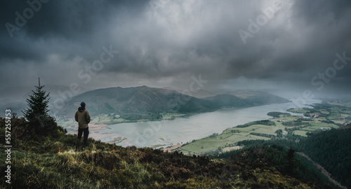 Hiker in the Stormy Mountains overlooking Lake