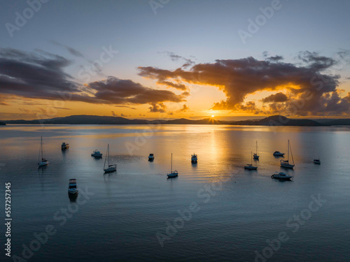 Aerial sunrise waterscape with boats  clouds and sun rays