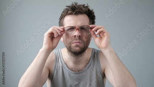 Surprised man in big glasses with WOW expression on gray backgound