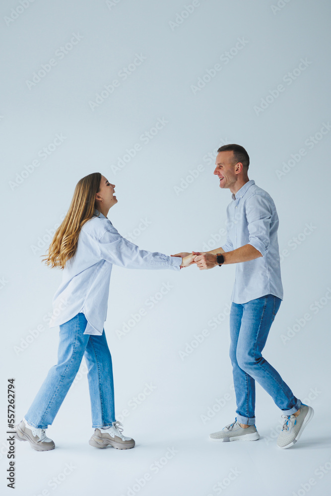 Photo of happy couple wearing white shirts, blue jeans, isolated white background. A man and a woman are hugging on a white background Photo of happy couple wearing white shirts, blue jeans, isolated white background. A man and a woman are hugging on a white background