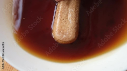 The process of cooking tiramisu. the cook dips savoiardi, savoyardi, adyfinger (biscuit), sponge fingers, boudoirs, baby fingers in coffee and spreads it on mascarpone