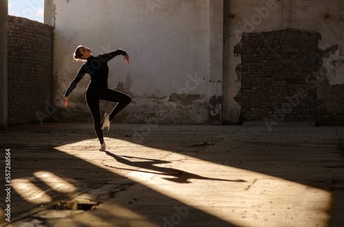 Fototapete Ballerina dancing in an abandoned building on a sunny day