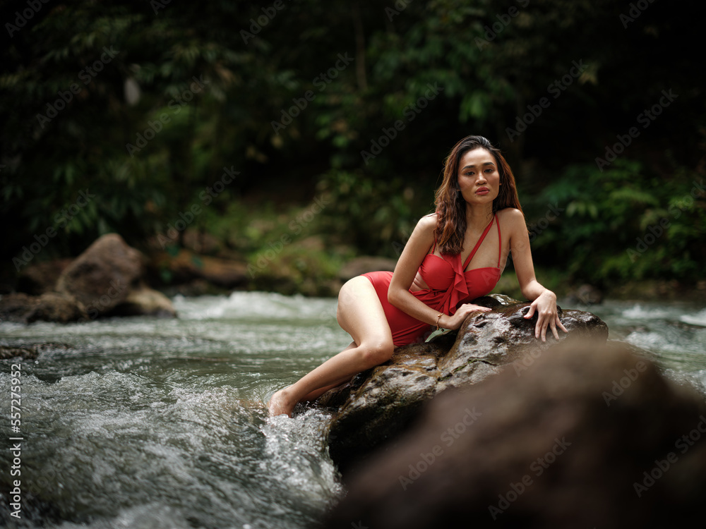 Portraiture shot of a beautiful Asian female model in bikini at a river Portraiture shot of a beautiful Asian female model in bikini at a river