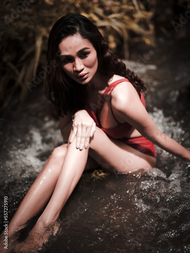 Portraiture shot of a beautiful Asian female model in bikini at a river