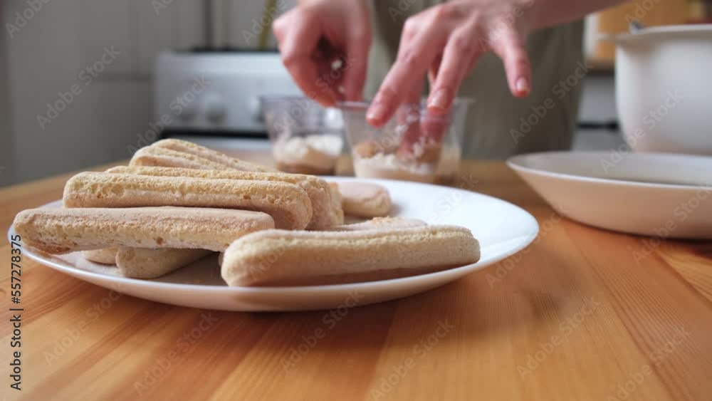 the process of cooking tiramisu. the cook lays out and smears