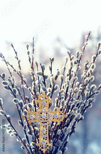 christianity cross and fluffy pussy willow branches on abstract blurred natural background. Easter holiday, Orthodox palm Sunday. symbol of Christianity, faith in God, prayer. spring season.
