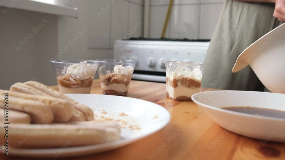 the process of cooking tiramisu. the cook lays out and smears