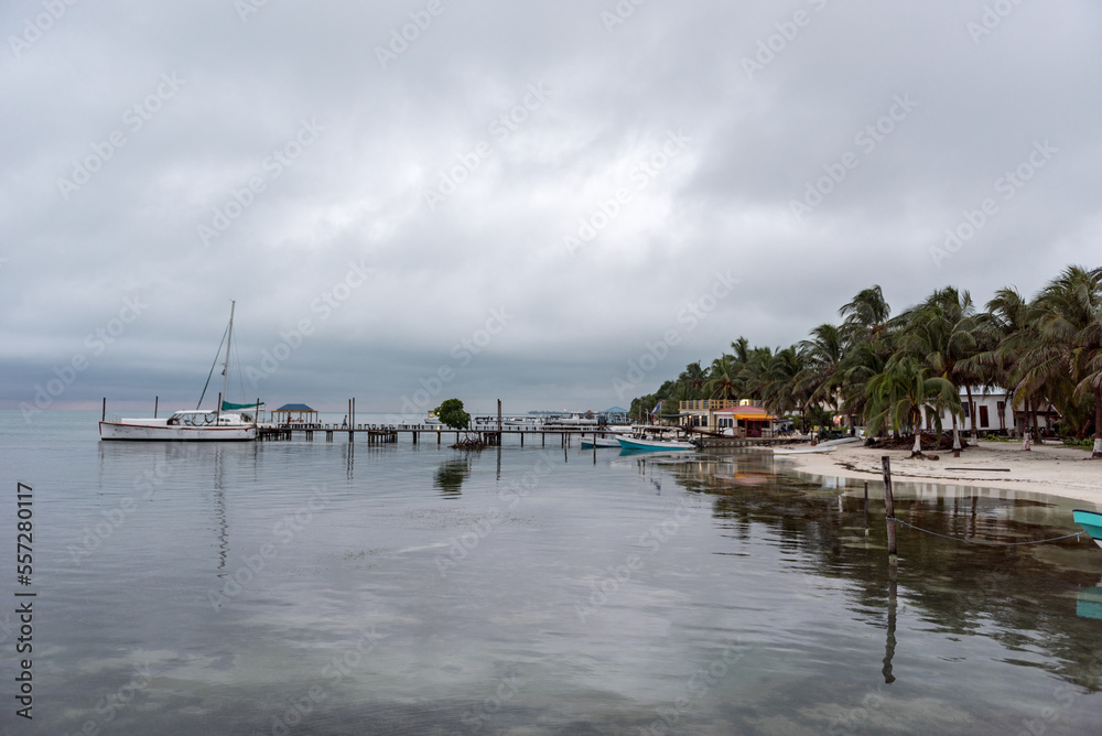 Obraz premium Caye Caulker Island in Caribbean Sea. Cloudy Morning And Calm Water in Pier. Belize. Caribbean Island