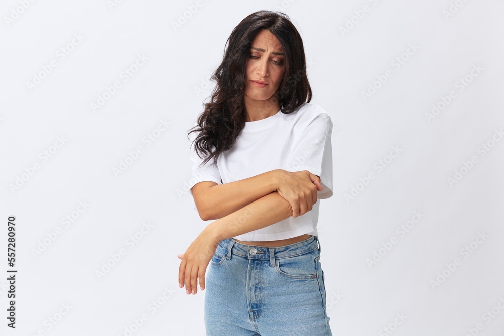 Woman pain in her arm, wrist sprain, bruised elbow in a white t-shirt on a white background, copy space Woman pain in her arm, wrist sprain, bruised elbow in a white t-shirt on a white background, copy space