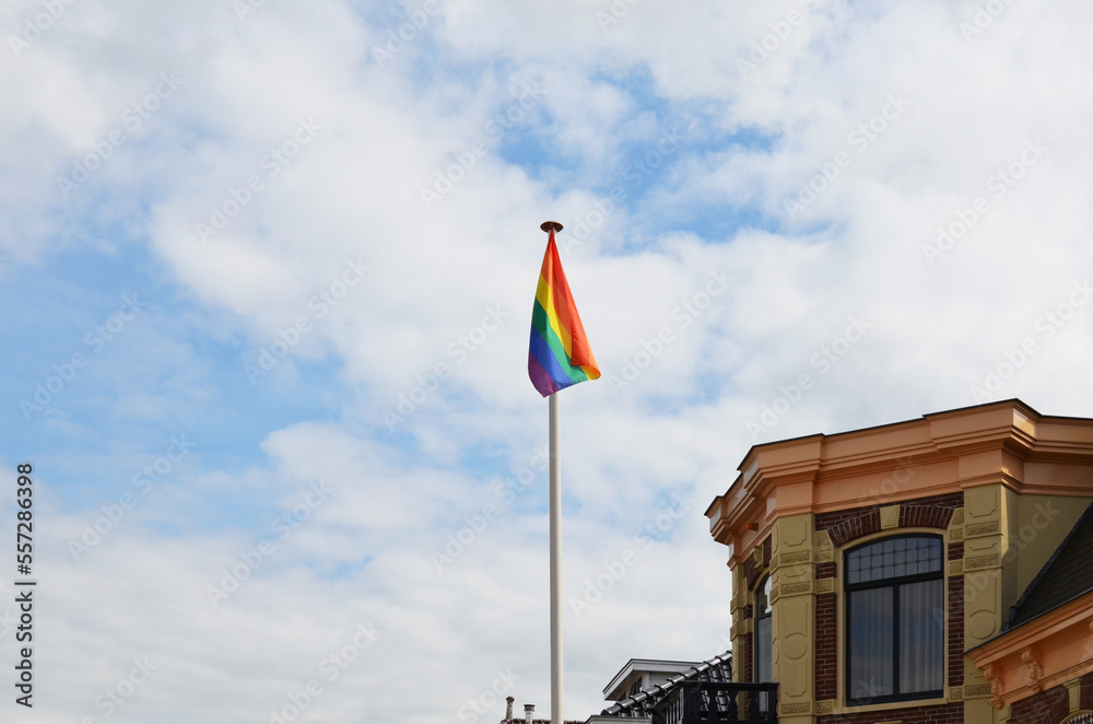 Bright rainbow LGBT flag against blue sky Bright rainbow LGBT flag against blue sky