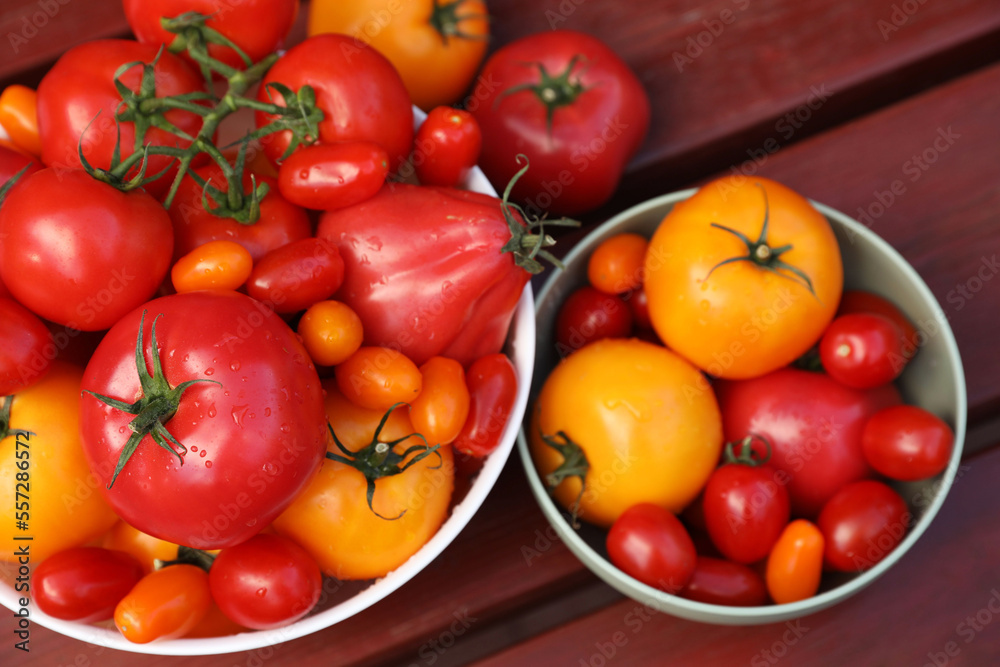 Bowls with fresh tomatoes on wooden table, flat lay