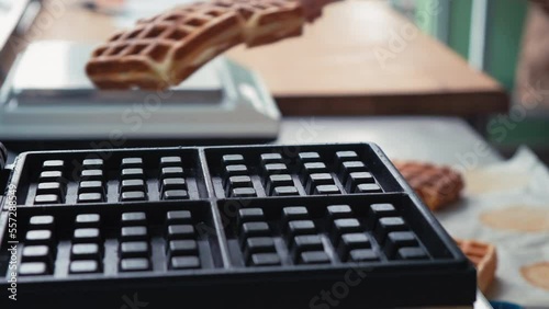 Close-up chef pours waffle batter in a waffle iron in a professional kitchen. Waffle making at the hotel with all-inclusive meals. belgian waffles in a waffle iron