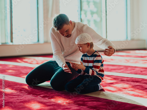 Photography Father and son in mosque praying and reading holly book quran together islamic e