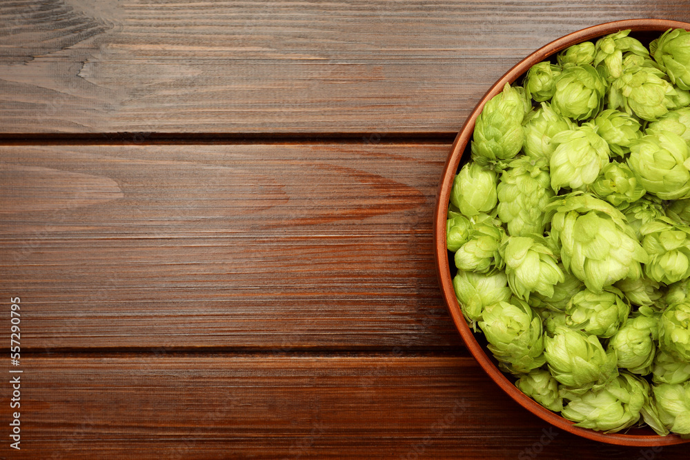 Bowl with fresh green hops on wooden table, top view. Space for text