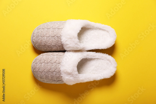 Pair of beautiful soft slippers on yellow background, top view