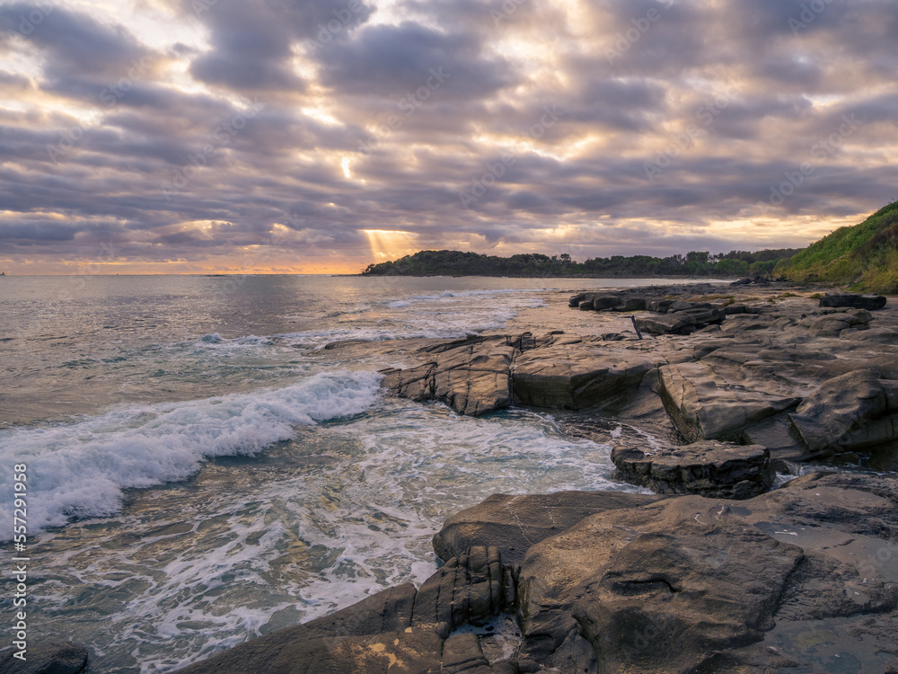 Coastal Sunrise with Waves Crashing on Rocks
